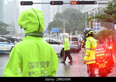 (230908) -- SHENZHEN, 8 settembre 2023 (Xinhua) -- agenti di polizia traffico diretto nella pioggia battente in una strada a Shenzhen, provincia del Guangdong della Cina meridionale, 8 settembre 2023. Influenzate dal sistema di nuvole residue al di fuori del tifone Haikui, l'undicesimo tifone di quest'anno, e monsone, molte città e contee nella regione del Delta del fiume delle Perle hanno sperimentato piogge torrenziali da giovedì, con precipitazioni estremamente pesanti che colpiscono alcune aree. Dalle 17:00 del giovedì alle 6:00 del venerdì, la pioggia media a Shenzhen è stata di 202,8 mm e la pioggia cumulativa massima ha raggiunto 469 mm, secondo il comune Foto Stock