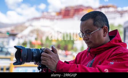 220603 -- LHASA, 3 giugno 2022 -- Jiang Wukai scatta foto dei concorrenti che arrivano al traguardo a Lhasa, capitale della regione autonoma Tibet del sud-ovest della Cina, 29 maggio 2022. PER ANDARE CON la caratteristica: Ciclisti dilettanti fare un giro epico in Tibet SPCHINA-TIBET-CICLISTI DILETTANTI-EPIC RIDE CN SunxFei PUBLICATIONxNOTxINxCHN Foto Stock