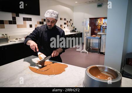 220609 -- BRUXELLES, 9 giugno 2022 -- Un membro dello staff mostra la produzione del cioccolato nel Belgian Chocolate Village a Bruxelles, in Belgio, 9 giugno 2022. Il Belgian Chocolate Village è un museo che mette in mostra la conoscenza, la storia e la cultura del cioccolato. BELGIO-BRUXELLES-MUSEO DEL CIOCCOLATO ZhengxHuansong PUBLICATIONxNOTxINxCHN Foto Stock