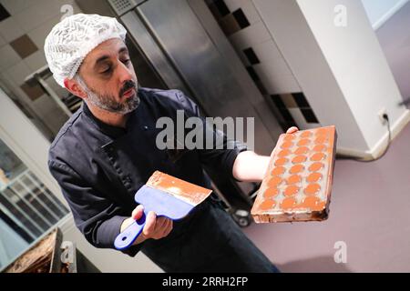 220609 -- BRUXELLES, 9 giugno 2022 -- Un membro dello staff mostra la produzione del cioccolato nel Belgian Chocolate Village a Bruxelles, in Belgio, 9 giugno 2022. Il Belgian Chocolate Village è un museo che mette in mostra la conoscenza, la storia e la cultura del cioccolato. BELGIO-BRUXELLES-MUSEO DEL CIOCCOLATO ZhengxHuansong PUBLICATIONxNOTxINxCHN Foto Stock