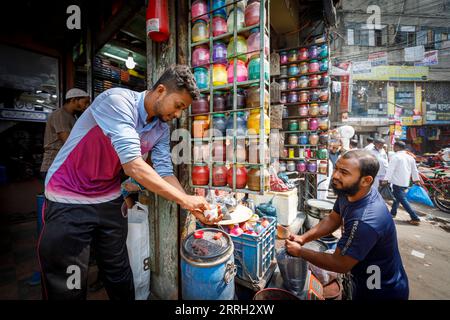 Un fornitore vende pigmenti colorati per la colorazione degli indumenti a un cliente di Purim Dhaka, la vecchia Dhaka. Il Bangladesh ha una lunga storia nella produzione di indumenti, dalla tessitura della musselina, alla produzione e lavorazione della iuta, agli indumenti su misura come i sari all'industria gigante moderna dei capi pronti, RMG. Foto Stock