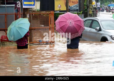 220615 -- GUWAHATI, 15 giugno 2022 -- le persone si sono inondate in una strada allagata dopo le piogge a Guwahati, città dell'Assam, stato nordorientale dell'India, 14 giugno 2022. Str/Xinhua INDIA-ASSAM-GUWAHATI-FLOOD JavedxDar PUBLICATIONxNOTxINxCHN Foto Stock