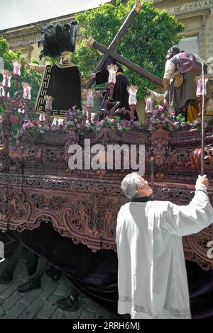 Jerez de la Frontera, Spagna - 8 settembre 2023: Il sacerdote accende le candele del Paso durante la settimana Santa a Jerez de la Frontera in Andalusia, Spagna. Foto Stock