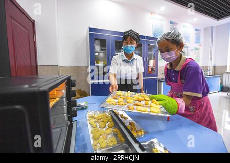 220625 -- BAOTOU, 25 giugno 2022 -- Uno studente impara a cucinare durante un'attività post-lezione in una scuola elementare a Baotou, regione autonoma della Mongolia interna, nella Cina settentrionale, 24 giugno 2022. Le scuole di Baotou organizzarono varie attività dopo le lezioni per arricchire il tempo scolastico degli studenti. CHINA-INNER MONGOLIA-BAOTOU-SCHOOL-AFTER-CLASS ACTIVITIES CN PENGXYUAN PUBLICATIONXNOTXINXCHN Foto Stock