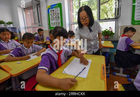 220625 -- BAOTOU, 25 giugno 2022 -- gli studenti imparano la calligrafia durante un'attività post-classe in una scuola elementare a Baotou, regione autonoma della Mongolia interna, 24 giugno 2022. Le scuole di Baotou organizzarono varie attività dopo le lezioni per arricchire il tempo scolastico degli studenti. CHINA-INNER MONGOLIA-BAOTOU-SCHOOL-AFTER-CLASS ACTIVITIES CN PENGXYUAN PUBLICATIONXNOTXINXCHN Foto Stock