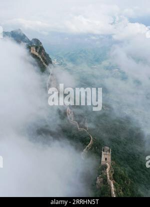 220704 -- PECHINO, 4 luglio 2022 -- foto aerea scattata il 4 luglio 2022 mostra nuvole galleggianti sopra la grande Muraglia nella zona di confine tra la contea di Luanping nella provincia di Hebei nel nord della Cina e il distretto di Miyun di Pechino, capitale della Cina. CHINA-BEIJING-GREAT WALL-SCENIC CN CHENXYEHUA PUBLICATIONXNOTXINXCHN Foto Stock