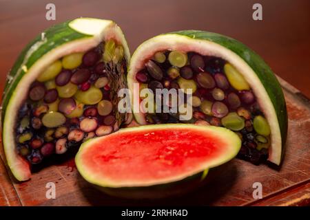 Aprire un cocomero riempito di gelatina e frutti di bosco. Dessert interessante e diverso Foto Stock