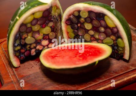 Aprire un cocomero riempito di gelatina e frutti di bosco. Dessert interessante e diverso Foto Stock