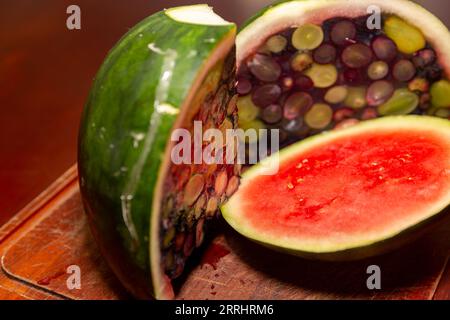 Aprire un cocomero riempito di gelatina e frutti di bosco. Dessert interessante e diverso Foto Stock