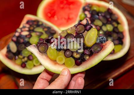 Aprire un cocomero riempito di gelatina e frutti di bosco. Dessert interessante e diverso Foto Stock