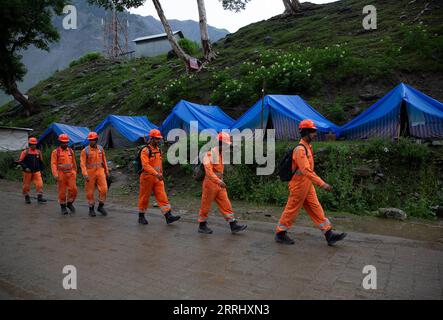 220709 -- SRINAGAR, 9 luglio 2022 -- i soccorritori camminano verso il sito di un'esplosione di nuvole che ha colpito vicino a un santuario di grotta indù, nell'area di Baltal del distretto di Ganderbal, a circa 110 km a nord-est della città di Srinagar, la capitale estiva del Kashmir controllato dagli indiani, 9 luglio 2022. Il bilancio delle vittime da un cloudburst che ha colpito vicino a un santuario di caverna indù nel Kashmir controllato dagli indiani è salito a 16 il sabato, hanno detto i funzionari, con più di 40 ancora mancanti. Il downpour ha innescato un'inondazione lampo il venerdì sera e ha spazzato via tende improvvisate e cucine comuni vicino al santuario Amarnath. KASHMIR-SHRINE-CLOUDBURST-RE Foto Stock