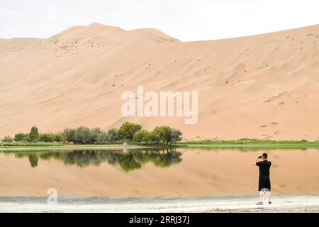 220713 -- BANNER DESTRO ARAXAN, 13 luglio 2022 -- Un turista scatta foto al deserto di Badain Jaran nella regione autonoma della Mongolia interna della Cina settentrionale, 13 luglio 2022. CINA-INTERNA MONGOLIA-ARAXAN-DESERTCN BeixHe PUBLICATIONxNOTxINxCHN Foto Stock