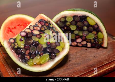 Aprire un cocomero riempito di gelatina e frutti di bosco. Dessert interessante e diverso Foto Stock