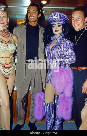 Besuch im Pariser Moulin Rouge, circa 1991, Bild: Yannick Noah, Französischer Tennisspieler, Popsängerin la Toya Jackson und Jean-Pierre Papin, Französischer Fussballspieler, Stürmer bei Olympique Marseille sowie eine Moulin Rouge Tänzerin. Foto Stock