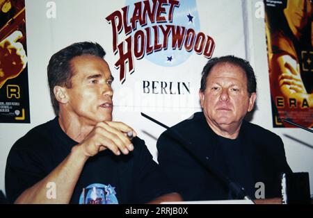 Action-Star Arnold Schwarzenegger, Hauptdarsteller im Action-Film: Eraser, hier mit Filmproduzenten Arnold Kopelson, während der Pressekonferenz im Berliner „Planet-Hollywood“, 1996. Foto Stock