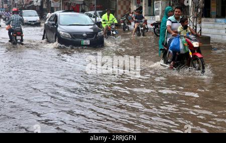 220722 -- LAHORE, 22 luglio 2022 -- le persone cavalcano attraverso l'acqua alluvionale dopo pesanti piogge monsoniche a Lahore, Pakistan, 21 luglio 2022. Almeno 282 persone sono state uccise e 211 altre ferite in incidenti separati legati alle piogge in Pakistan dal 14 giugno, mentre le forti calamità continuavano a colpire il paese, ha detto l'NDMA. Foto di /Xinhua PAKISTAN-LAHORE-FORTI PIOGGE JamilxAhmed PUBLICATIONxNOTxINxCHN Foto Stock