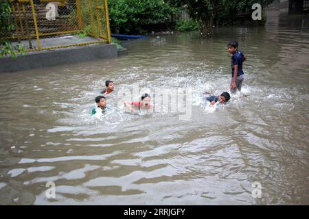 220722 -- LAHORE, 22 luglio 2022 -- i bambini giocano in acqua alluvionale su una strada scavata dall'acqua dopo le pesanti piogge monsoniche a Lahore, Pakistan, 21 luglio 2022. Almeno 282 persone sono state uccise e 211 altre ferite in incidenti separati legati alle piogge in Pakistan dal 14 giugno, mentre le forti calamità continuavano a colpire il paese, ha detto l'NDMA. Foto di /Xinhua PAKISTAN-LAHORE-FORTI PIOGGE JamilxAhmed PUBLICATIONxNOTxINxCHN Foto Stock