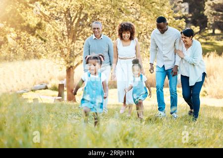 Parcheggia, cammina e fai felici generazioni di famiglia per legare, divertirti e parlare insieme. Amore, sorriso e figli con genitori e nonni Foto Stock