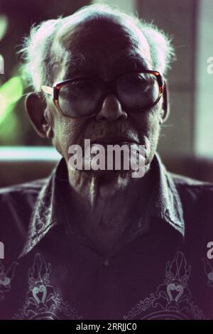 Splendido ritratto di un anziano stregone balinese che indossa occhiali Foto Stock