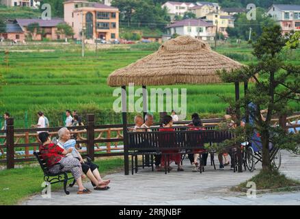 220731 -- JING AN, 31 luglio 2022 -- i turisti riposano nel villaggio di Sanping della città di Zhongyuan nella contea di Jing An, provincia di Jiangxi della Cina orientale, 27 luglio 2022. Situata ad un'altitudine di oltre 600 metri, la città di Zhongyuan nella provincia orientale dello Jiangxi della Cina ha un tasso di copertura forestale di quasi il 90%. Di conseguenza, la temperatura media qui è di 6-10 gradi Celsius più fredda di quella della vicina Nanchang, la capitale della provincia di Jiangxi, rendendo la città una località estiva favorevole per i turisti che evitano il caldo estivo. Questo posto era povero, e ci guadagnavamo da vivere tagliando i bambù, sai Foto Stock