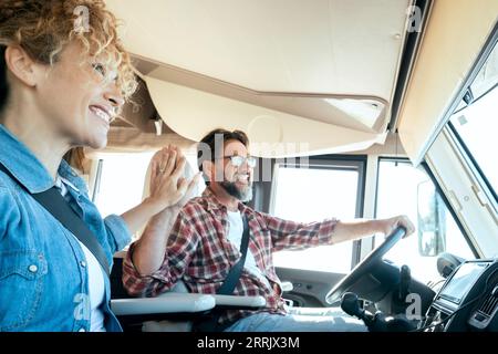 Buon viaggio di coppia e viaggio in camper. Concetto di noleggio camper per per la vazione alternativa . Turista con cinque gesti all'interno di un veicolo ricreativo. Vanlife. Cambiare la vita Foto Stock