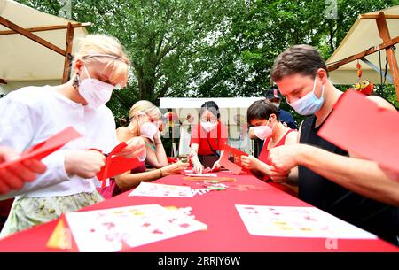 220814 -- BERLINO, 14 agosto 2022 -- la gente impara il taglio della carta durante il festival culturale Culture Meets Garden at the Gardens of the World a Berlino, Germania, il 13 agosto 2022. Il festival si è tenuto qui dal 13 al 14 agosto. GERMANIA-BERLINO-FESTIVAL CULTURALE RenxPengfei PUBLICATIONxNOTxINxCHN Foto Stock