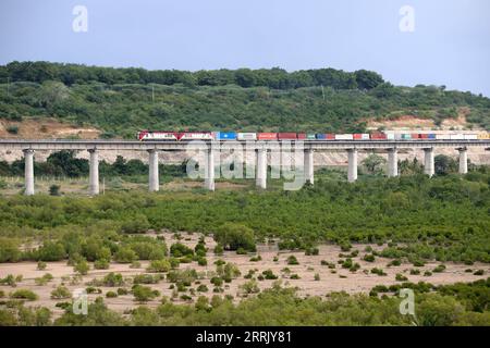 220814 -- NAIROBI, 14 agosto 2022 -- Un treno merci corre sul binario della ferrovia Mombasa-Nairobi bypassando le mangrovie a Mombasa, in Kenya, il 27 luglio 2022. Xinhua titoli: Ferrovie moderne di costruzione cinese abilitatore chiave per la visione 2030 del Kenya DongxJianghui PUBLICATIONxNOTxINxCHN Foto Stock