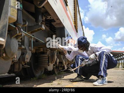 220814 -- NAIROBI, 14 agosto 2022 -- l'istruttore cinese Yang Ming L e la sua apprendista keniota Concilia ispezionano la locomotiva a Nairobi, Kenya, il 22 marzo 2021. Xinhua titoli: Ferrovie moderne di costruzione cinese abilitatore chiave per la visione 2030 del Kenya LixYan PUBLICATIONxNOTxINxCHN Foto Stock