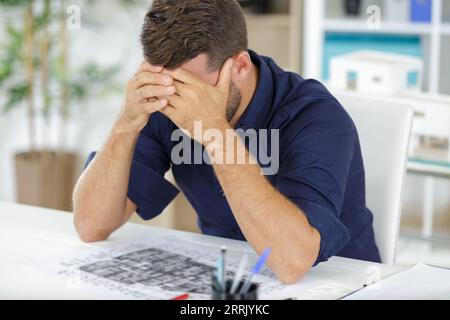 primo piano del maschio architetto sotto pressione e sotto stress Foto Stock