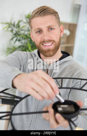 sostituzione della batteria in un orologio a parete al quarzo Foto Stock