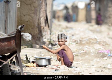 220819 -- ISLAMABAD, 19 agosto 2022 -- un ragazzo afghano rifugiato siede vicino alla sua casa improvvisata in una baraccopoli a Islamabad, capitale del Pakistan, 18 agosto 2022. La giornata mondiale umanitaria è stata celebrata il 19 agosto. PAKISTAN-ISLAMABAD-AFGHANI RIFUGIATI AhmadxKamal PUBLICATIONxNOTxINxCHN Foto Stock