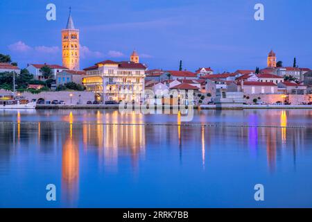 Europa, Croazia, Primorje-Gorski Kotar County, Rab Island, Rab, la città vecchia e gli edifici che si affacciano sul porticciolo al crepuscolo Foto Stock