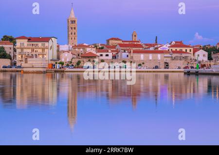 Europa, Croazia, Primorje-Gorski Kotar County, isola di Rab, città vecchia di Rab e gli edifici che si affacciano sul porticciolo al crepuscolo Foto Stock