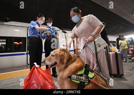 220823 -- GUANGDONG, 23 agosto 2022 -- il membro dello staff Luo min 1st L coordina il servizio passeggeri per Zhang li con il direttore del treno li Shuang 2nd L alla stazione ferroviaria nord di Shenzhen a Shenzhen, nella provincia del Guangdong della Cina meridionale, 19 agosto 2022. Zhang li, una persona ipovedente, è tornato a Huizhou da Heyuan nella provincia del Guangdong in treno. Ad accompagnarla durante il viaggio c'era il suo cane guida Man Yue. Dal 2017, Man Yue è stato in molti posti con Zhang li ed è diventato un membro della famiglia di Zhang. CHINA-GUANGDONG-GUIDE DOG-TRIP CN MAOXSIQIAN PUBLICATIONXNOTXINXCHN Foto Stock