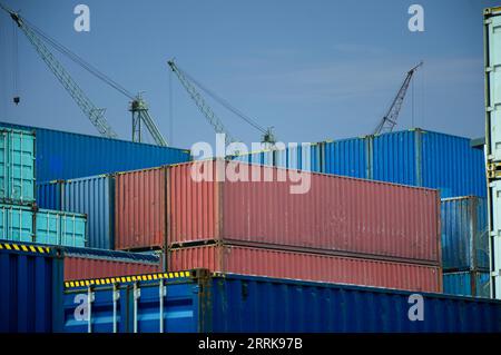 container in attesa di trasporto e sul retro c'è una gru per sollevare il container Foto Stock