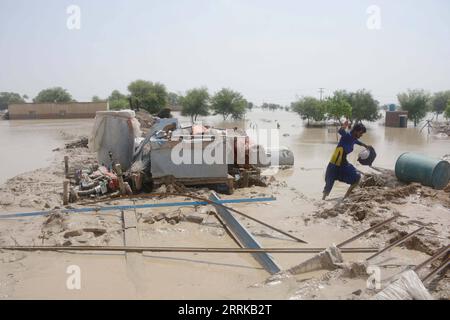 220828 -- RAJANPUR, 28 agosto 2022 -- Un uomo prende oggetti utilizzabili da una casa di alluvione nel distretto di Rajanpur, nella provincia del Punjab del Pakistan, il 27 agosto 2022. Il bilancio delle vittime in incidenti separati causati da forti piogge in tutto il Pakistan è salito a 1.000 dall'inizio della stagione dei monsoni il 14 giugno, l'Autorità nazionale per la gestione dei disastri NDMA ha detto sabato sera. Foto di /Xinhua PAKISTAN-RAJANPUR-FLOOD Mansoor PUBLICATIONxNOTxINxCHN Foto Stock