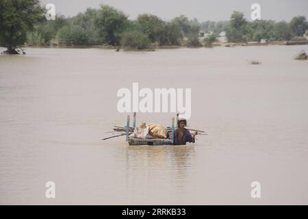 220828 -- RAJANPUR, 28 agosto 2022 -- Una donna con i suoi effetti personali cammina attraverso l'acqua alluvionale nel distretto di Rajanpur, nella provincia del Punjab del Pakistan, il 27 agosto 2022. Il bilancio delle vittime in incidenti separati causati da forti piogge in tutto il Pakistan è salito a 1.000 dall'inizio della stagione dei monsoni il 14 giugno, l'Autorità nazionale per la gestione dei disastri NDMA ha detto sabato sera. Foto di /Xinhua PAKISTAN-RAJANPUR-FLOOD Mansoor PUBLICATIONxNOTxINxCHN Foto Stock