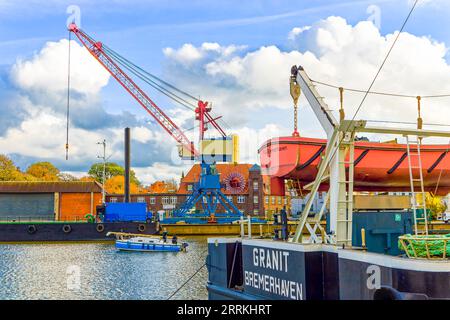 Porto di Brak con grande gru di carico, nave da carico e barca a vela Foto Stock