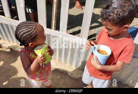 220912 -- WINDHOEK, 12 settembre 2022 -- i bambini tengono tazze con cibo servito al Needy Hearts Soup Kitchen di Hakahana, un insediamento informale a Windhoek, Namibia, il 12 settembre 2022. PER ANDARE CON caratteristiche: La cucina della zuppa porta cura, amore per i bambini di insediamento informale della NAMIBIA foto di /Xinhua NAMIBIA-WINDHOEK-NEEDY HEARTS ZUPPA KITCHEN NdalimpingaxIita PUBLICATIONxNOTxINxCHN Foto Stock