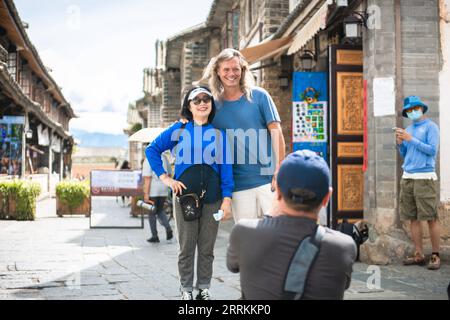 220913 -- DALI, 13 settembre 2022 -- Brian Linden posa per una foto con un turista nella città vecchia di Xizhou nella provincia dello Yunnan della Cina sud-occidentale, 28 agosto 2022. PER ANDARE CON la caratteristica: Il tempo libero incontra il patrimonio nel centro culturale rurale della Cina CINA-YUNNAN-DALI-IMPRENDITORE AMERICANO CN CaoxMengyao PUBLICATIONxNOTxINxCHN Foto Stock