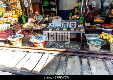 Vendita di pesce e frutti di mare, vendita di prodotti alimentari su rotaie, mercato ferroviario di Maeklong, mercato ferroviario di Talad Rom Hub, vicino a Bangkok, Samut Songkhram, Thailandia, Asia. Foto Stock