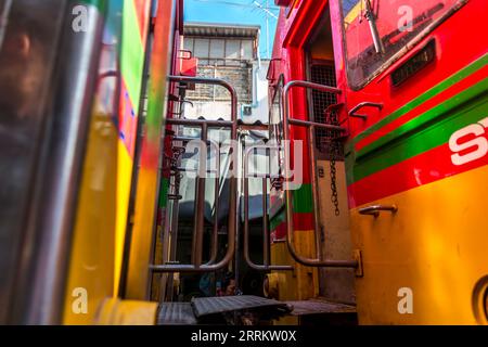 Il treno passa attraverso le bancarelle, vende cibo su rotaie, il mercato ferroviario di Maeklong, il mercato ferroviario di Talad Rom Hub, vicino a Bangkok, Samut Songkhram, Thailandia, Asia Foto Stock
