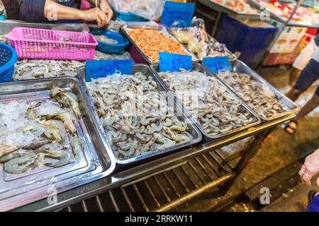 Vendita di pesce e frutti di mare, mercato ferroviario di Maeklong, mercato ferroviario di Talaad Room Hood, vendita di cibo su rotaie, vicino a Bangkok, Samut Songkhram, Thailandia, Asia. Foto Stock