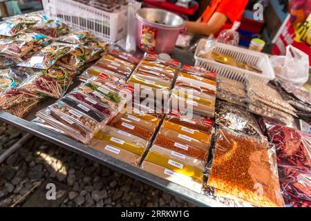 Bancarelle di spezie, vendita di cibo su rotaie, mercato ferroviario di Maeklong, mercato ferroviario di Talad Rom Hub, vicino a Bangkok, Samut Songkhram, Thailandia, Asia Foto Stock