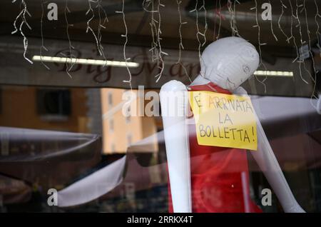 220921 -- ROMA, 21 settembre 2022 -- un manichino gonfiabile e un cartello giallo che legge il disegno di legge sono arrivati si vedono al bar Big Mamy a Roma, Italia, 17 settembre 2022. Al bar Big Mamy di Roma, è arrivato un manichino gonfiabile appeso alla finestra con un cartello giallo che legge il conto. Laura Ramoni, proprietaria del bar, ha detto a Xinhua che la bolletta elettrica del bar nei mesi di giugno e luglio è stata di circa 2.600 euro, quasi triplicata rispetto allo stesso periodo dello scorso anno. Non possiamo pagare il conto, ha detto. Devo licenziare due persone che lavoravano qui e ho aumentato il prezzo del caffè di 0,1 euro. IO Foto Stock