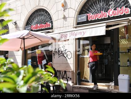 220921 -- ROMA, 21 settembre 2022 -- Sara, figlia di Laura Ramoni, serve caffè per i clienti al bar Big Mamy di Roma, 17 settembre 2022. Al bar Big Mamy di Roma, è arrivato un manichino gonfiabile appeso alla finestra con un cartello giallo che legge il conto. Laura Ramoni, proprietaria del bar, ha detto a Xinhua che la bolletta elettrica del bar nei mesi di giugno e luglio è stata di circa 2.600 euro, quasi triplicata rispetto allo stesso periodo dello scorso anno. Non possiamo pagare il conto, ha detto. Devo licenziare due persone che lavoravano qui e ho aumentato il prezzo del caffè di 0,1 euro. Mi sono sentito impiccato, e posso farlo Foto Stock