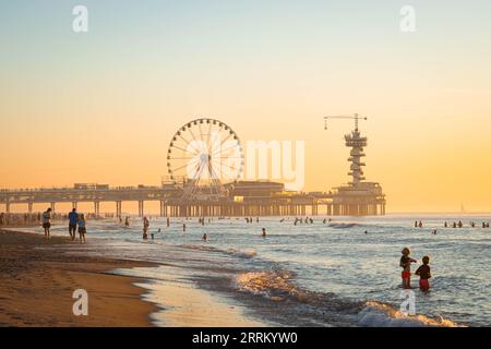 Vista panoramica sulla spiaggia e sul molo di Scheveningen, vicino alla città dell'Aia, in una soleggiata serata di tarda estate. Foto Stock