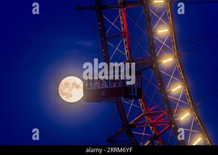 Vienna, luna piena, luna di miele alla ruota panoramica nel parco divertimenti Prater nel 02. Distretto Leopoldstadt, Vienna, Austria Foto Stock