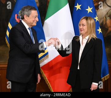 221024 -- ROMA, 24 ottobre 2022 -- il nuovo primo ministro italiano Giorgia Meloni R riceve la campana consegnata dal primo ministro uscente Mario Draghi durante la cerimonia di consegna a Palazzo Chigi a Roma, in Italia, 23 ottobre 2022. Meloni domenica ha invocato l'unità mentre simbolicamente ha preso il potere in un paese che ha affrontato quelle che ha detto essere sfide multiple. Anche se Meloni ha prestato giuramento sabato, il primo ministro uscente Mario Draghi ha solennemente passato il potere alla sua domenica in un incontro televisivo a Palazzo Chigi, sede ufficiale del governo italiano. Foto di /Xinhua ITALY-ROME-NEW PM-HANDOVER CERE Foto Stock