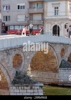 Trainare le donne sul famoso Ponte Latino sul Rivrer Miljacka in una giornata estiva nella città di Sarajevo, Bosnia ed Erzegovina, 8 settembre 2023 Foto Stock